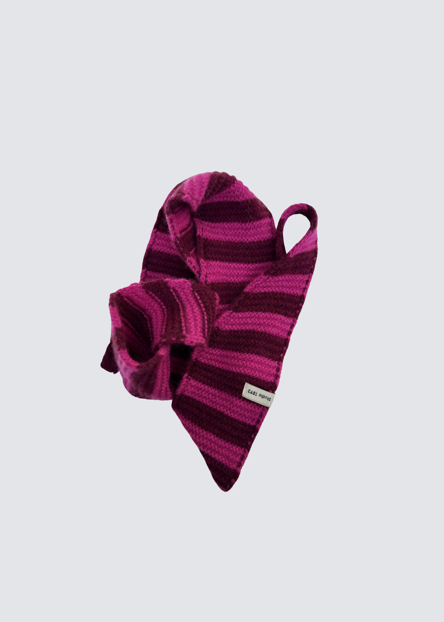 Gestrickter schmaler Schal in Olive und Rosa. Spitz zulaufend. Dezentes Studio 1893 Logo am Ende des Schals. Flatshot, gewickelter Schal.