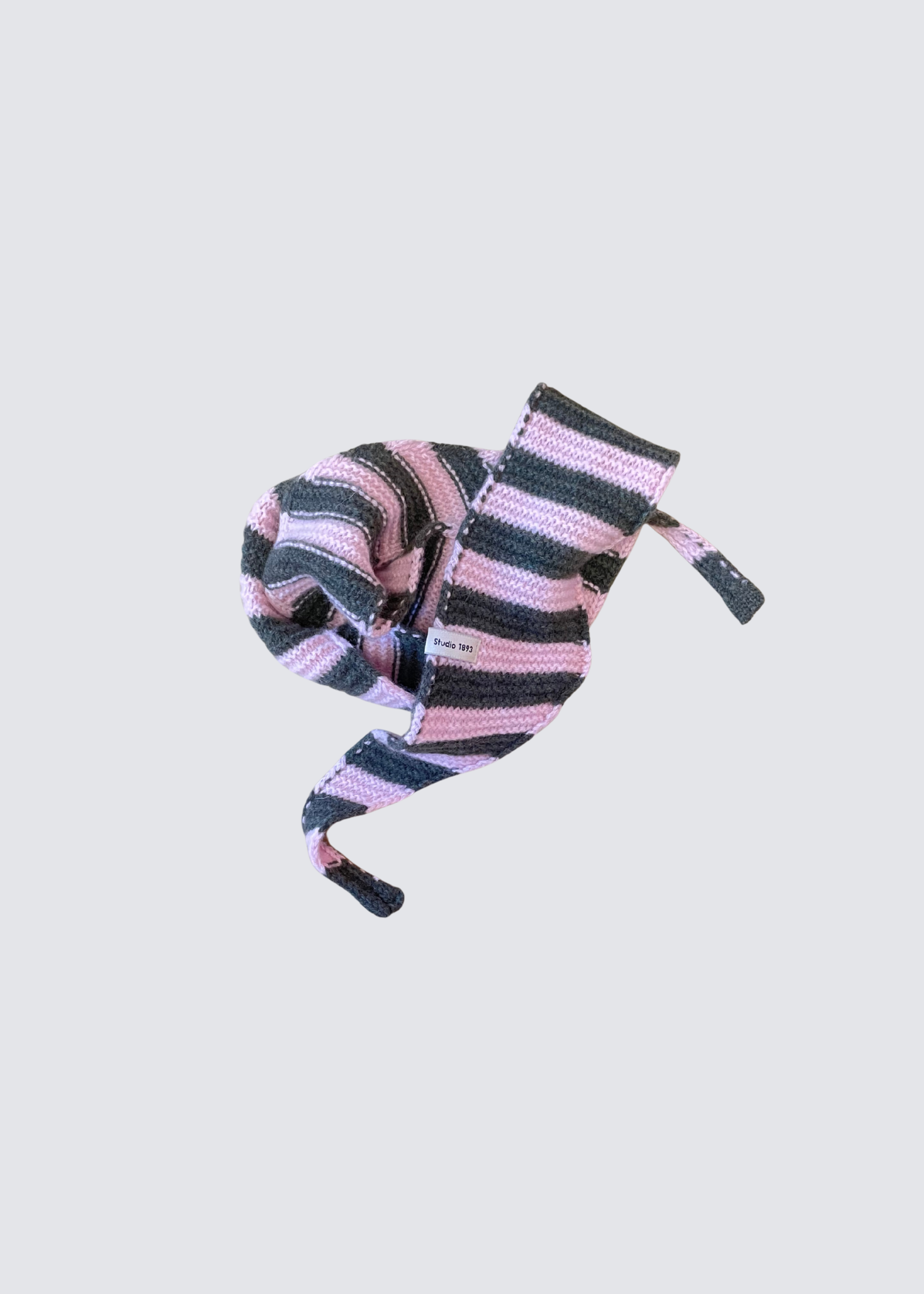 Gestrickter schmaler Schal in Olive und Rosa. Spitz zulaufend. Dezentes Studio 1893 Logo am Ende des Schals. Flatshot.2