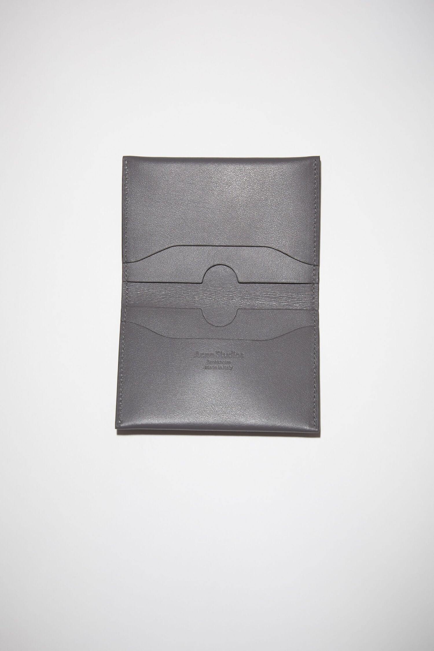 Grauer Leder Cardholder mit Silbernen Acne Studios Logo. Detail Shot geöffneter Cardholder.