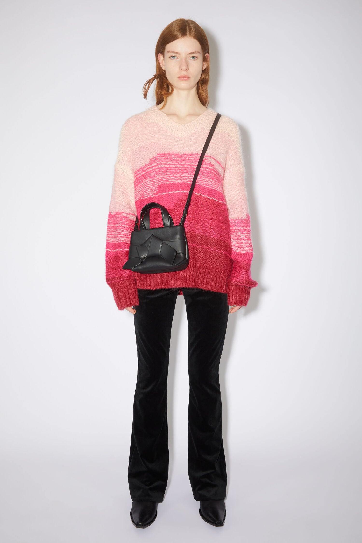 Schwarze Micro Bag mit Schleifen Detail auf der Vorderseite. Model Bild.