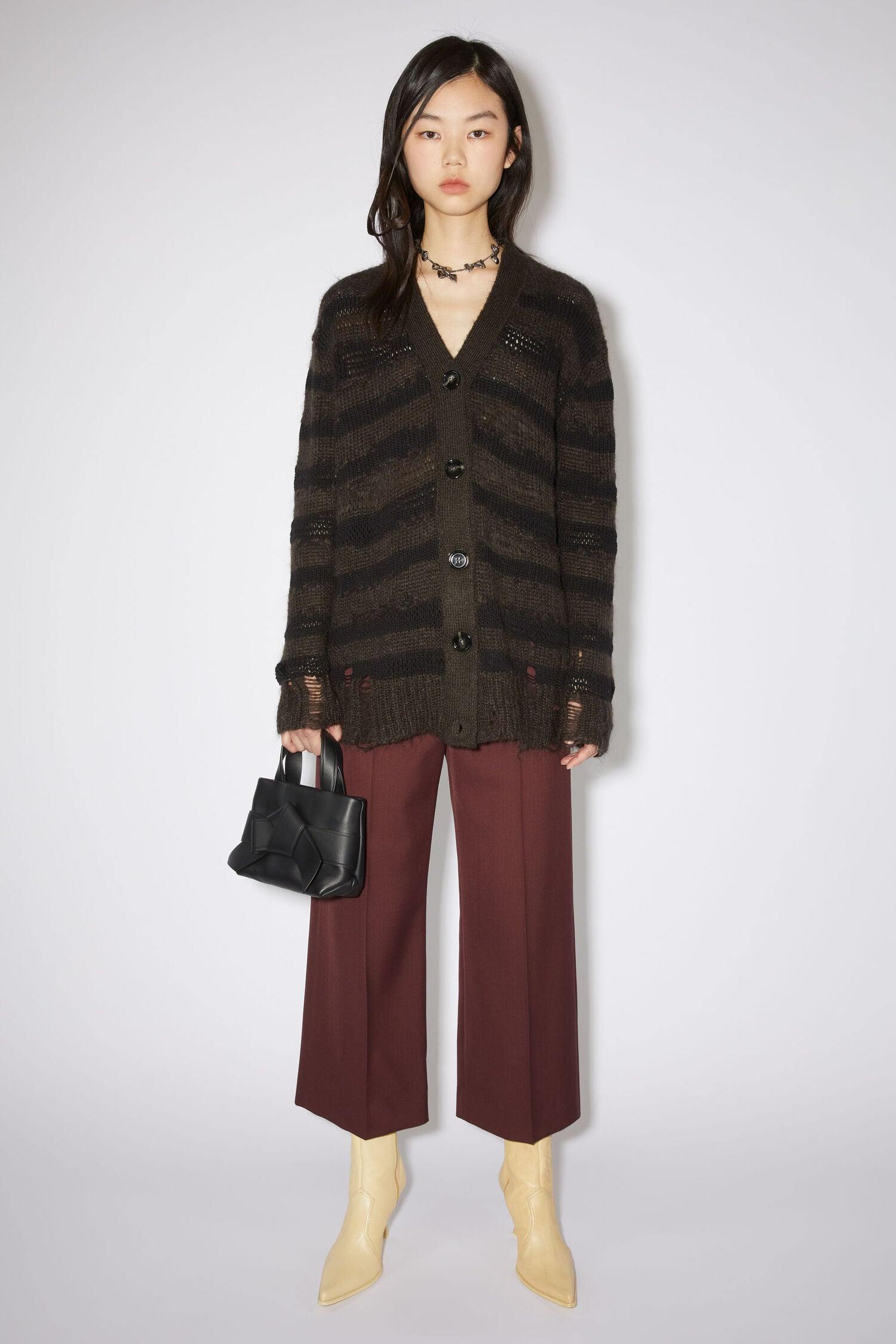 Schwarze Micro Bag mit Schleifen Detail auf der Vorderseite. Model Bild.