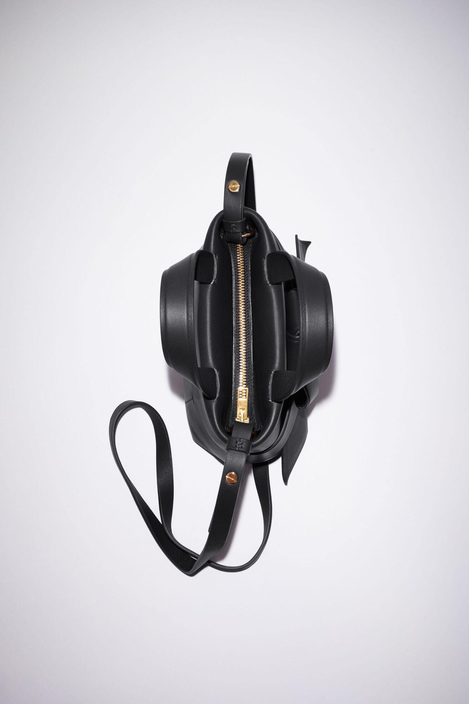 Schwarze Micro Bag mit Schleifen Detail auf der Vorderseite. Reißverschluss Flat Shot.