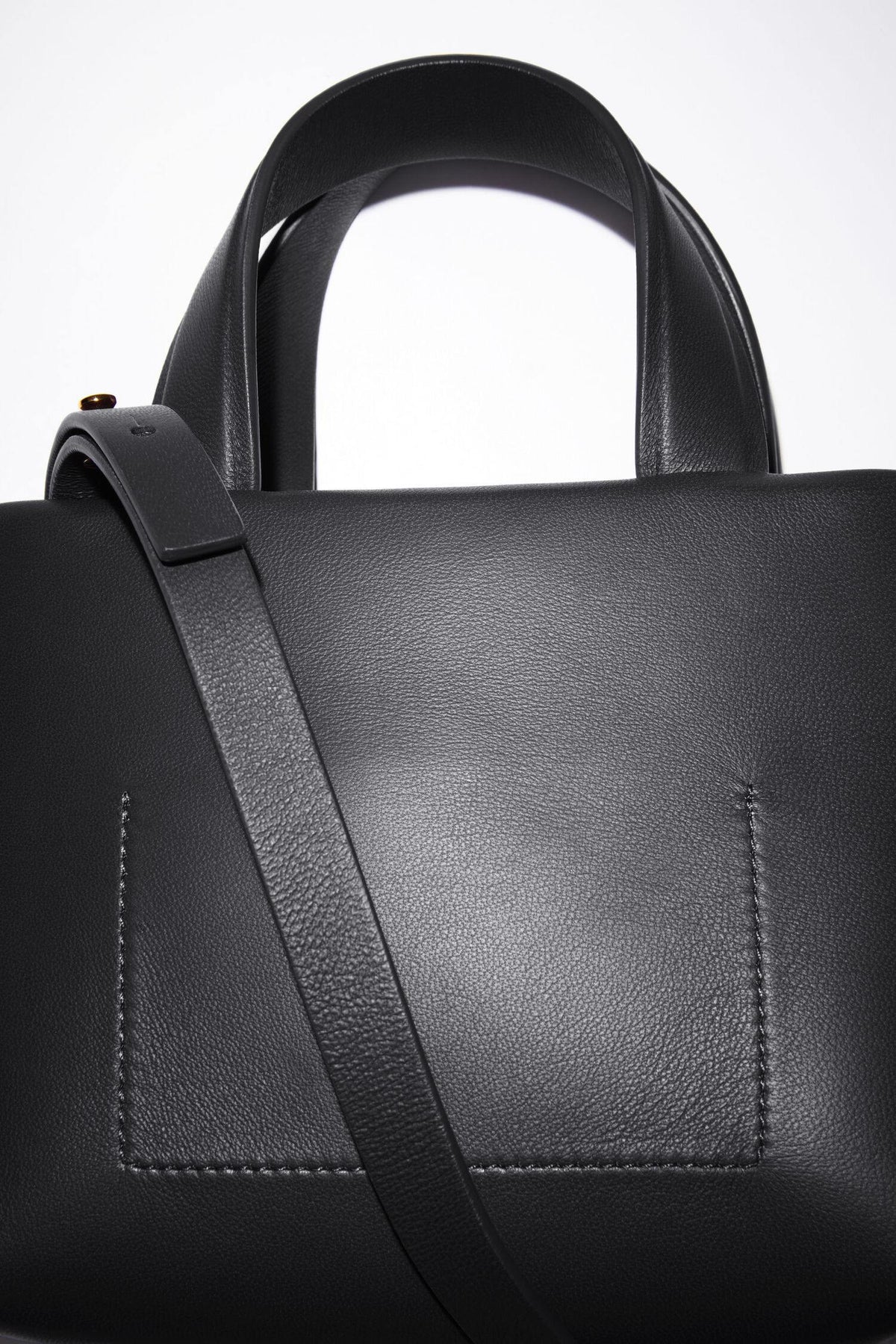 Schwarze Micro Bag mit Schleifen Detail auf der Vorderseite. Detail Shot Rückseite.
