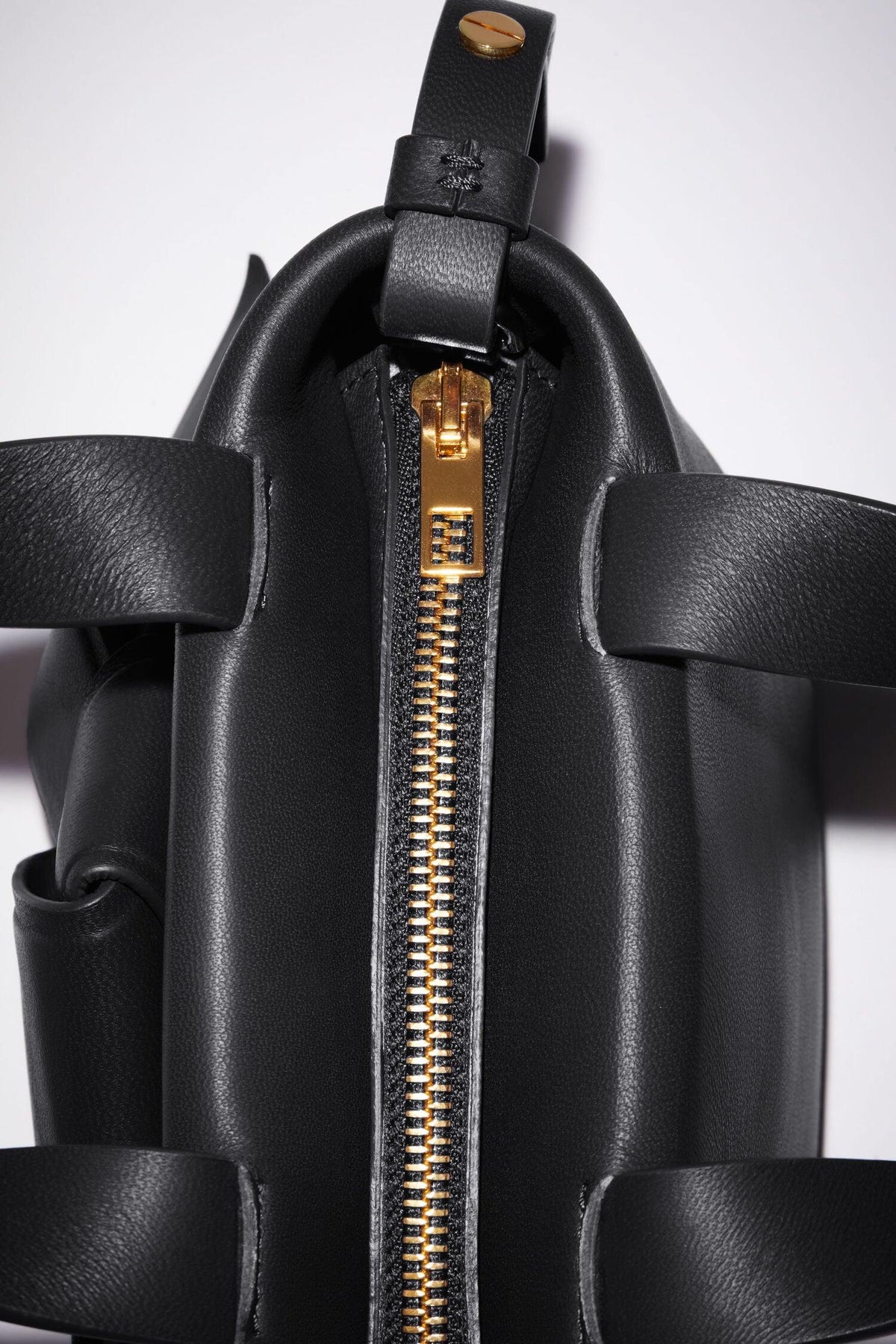 Schwarze Micro Bag mit Schleifen Detail auf der Vorderseite. Reißverschluss Detail Shot.